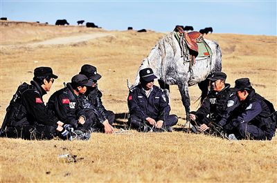 在玛曲县齐哈玛乡草原，玛曲县公安局草原骑警大队大队长宋林平（右三）在与队员交流情况。